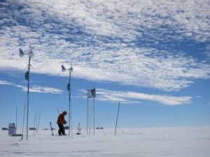 Jan sets up a GPS station, powered by solar panels and wind generators. This station will track the movement of the ice over the next year. Photo: Damon Davies.